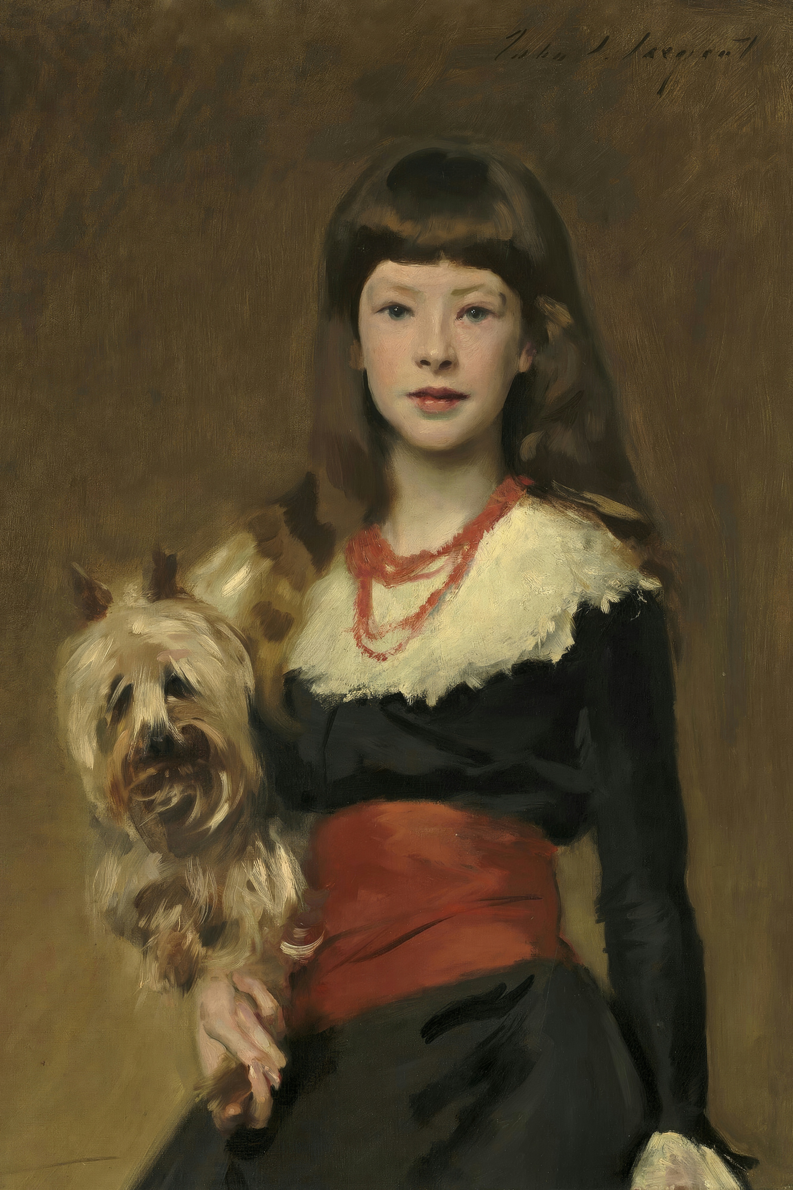 A girl with long dark hair and a fringe holds a Yorkshire terrier against her dark dress with a red sash.