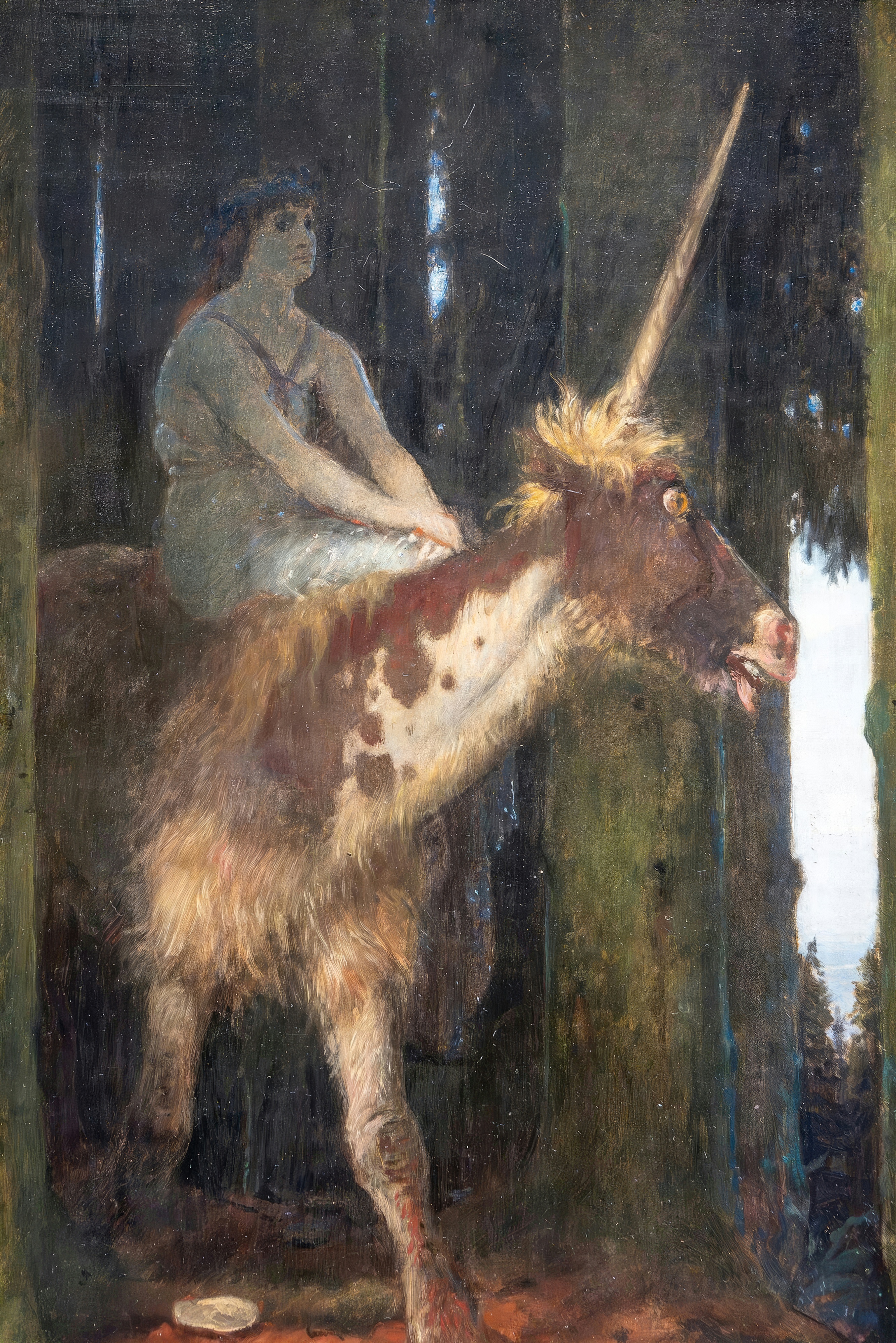A woman rides a unicorn out of a dark, dense forest, looking straight at the viewer.