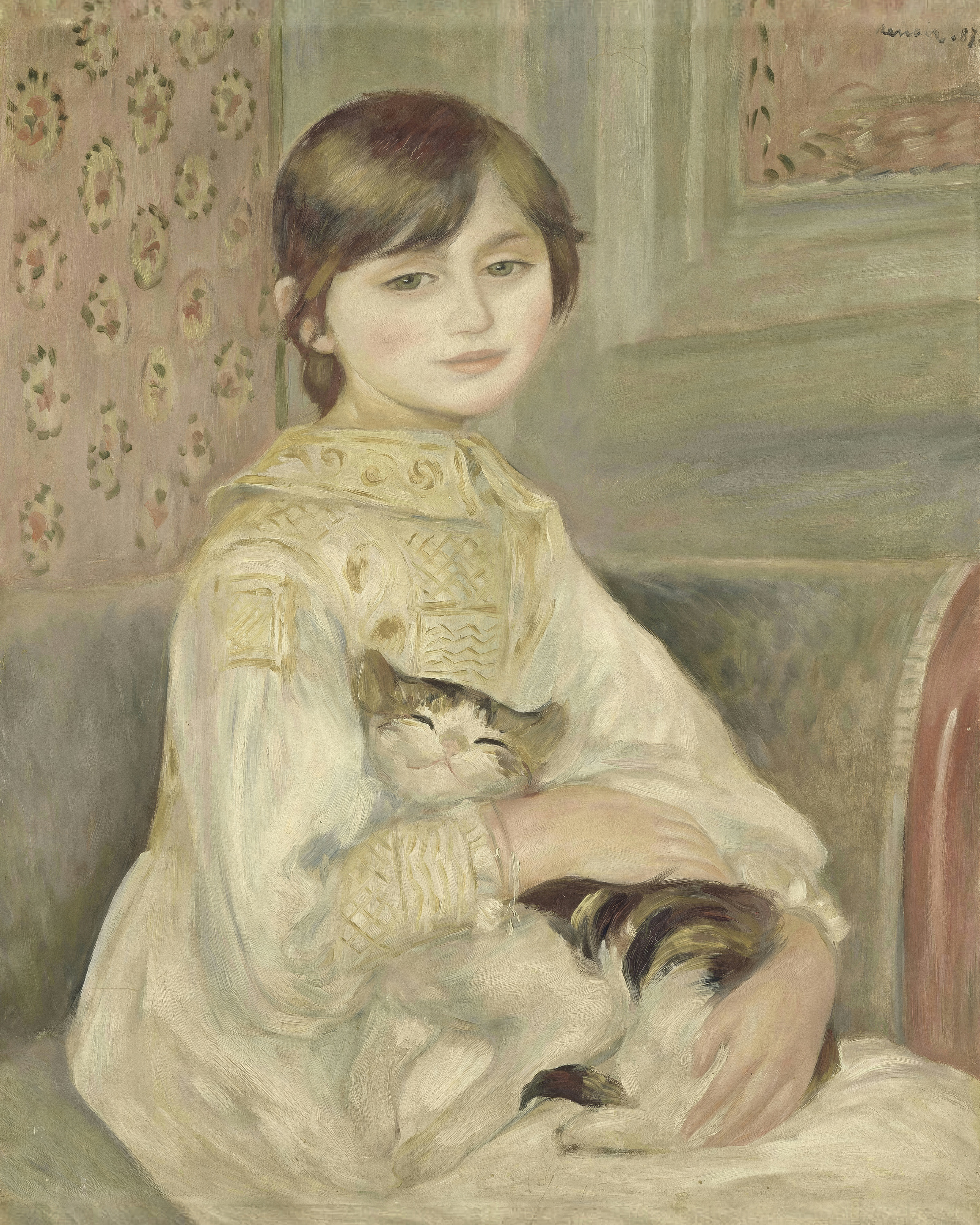A girl with a short brown bob sits in a white dress holding a sleeping tabby cat in her lap.