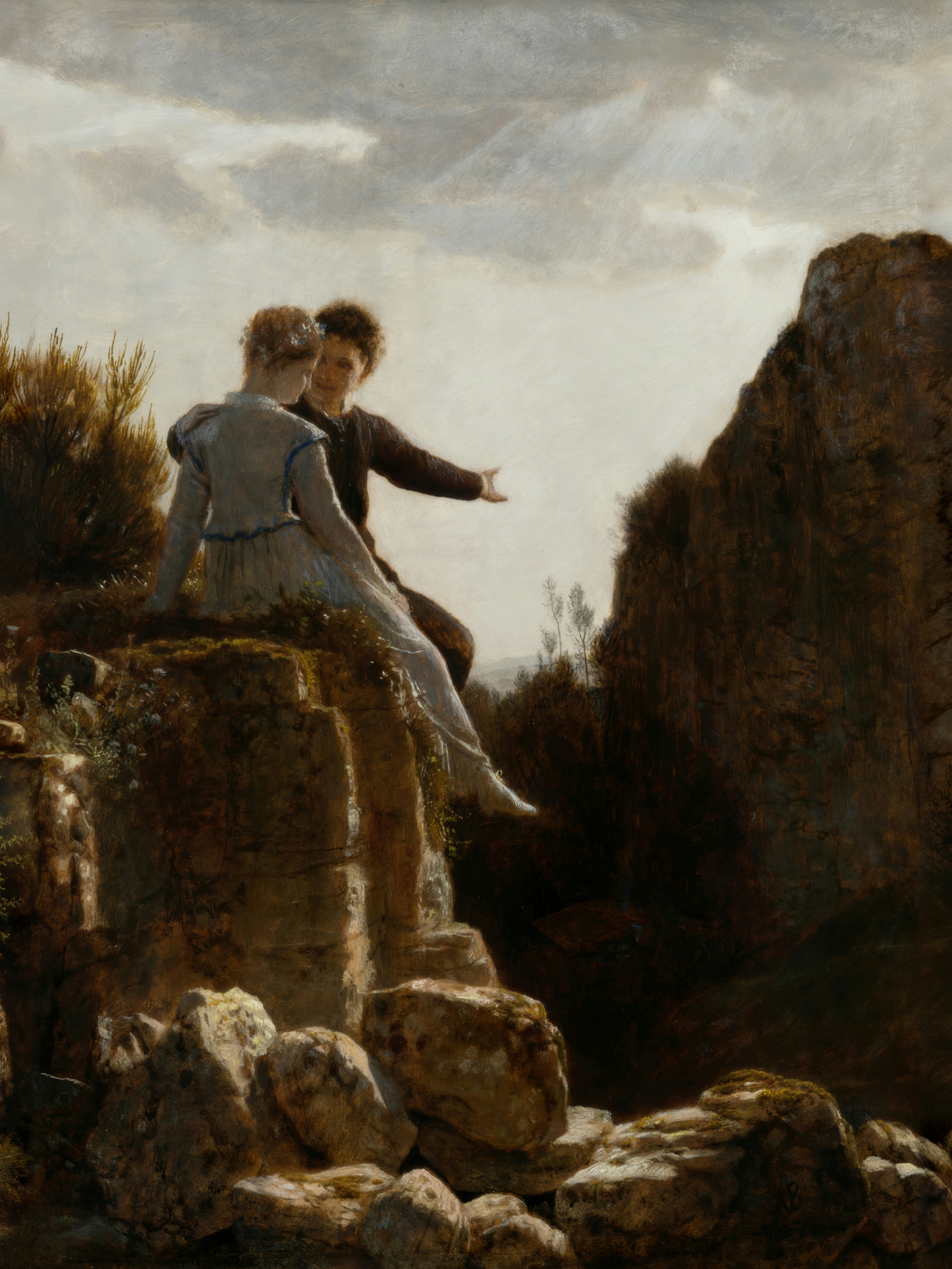 A young couple sits on a rocky precipice; the man gestures out over a wide, wild landscape.