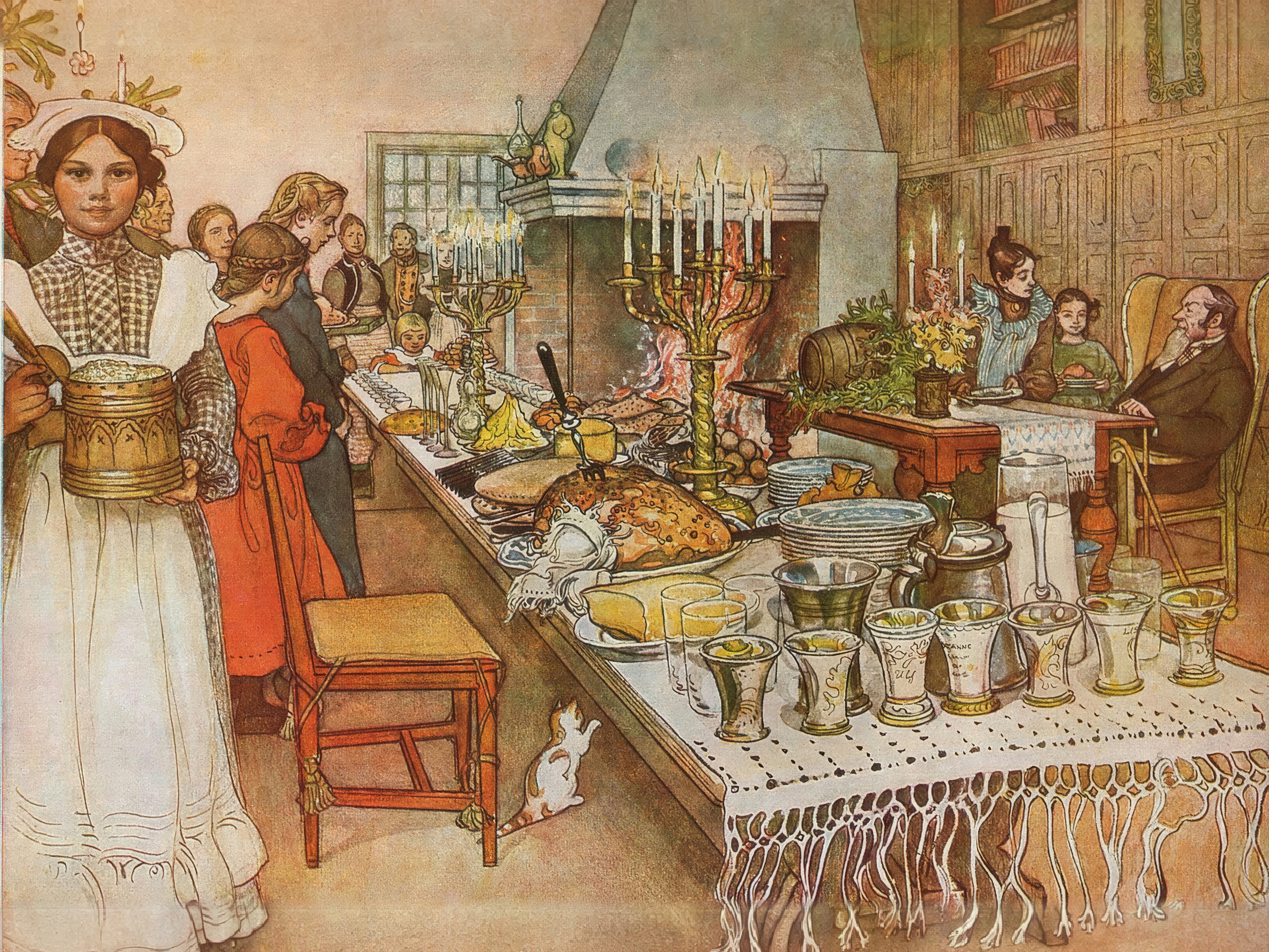 A long Christmas table laid with food and glasses, with candles and a great fire, and family members gathered around.