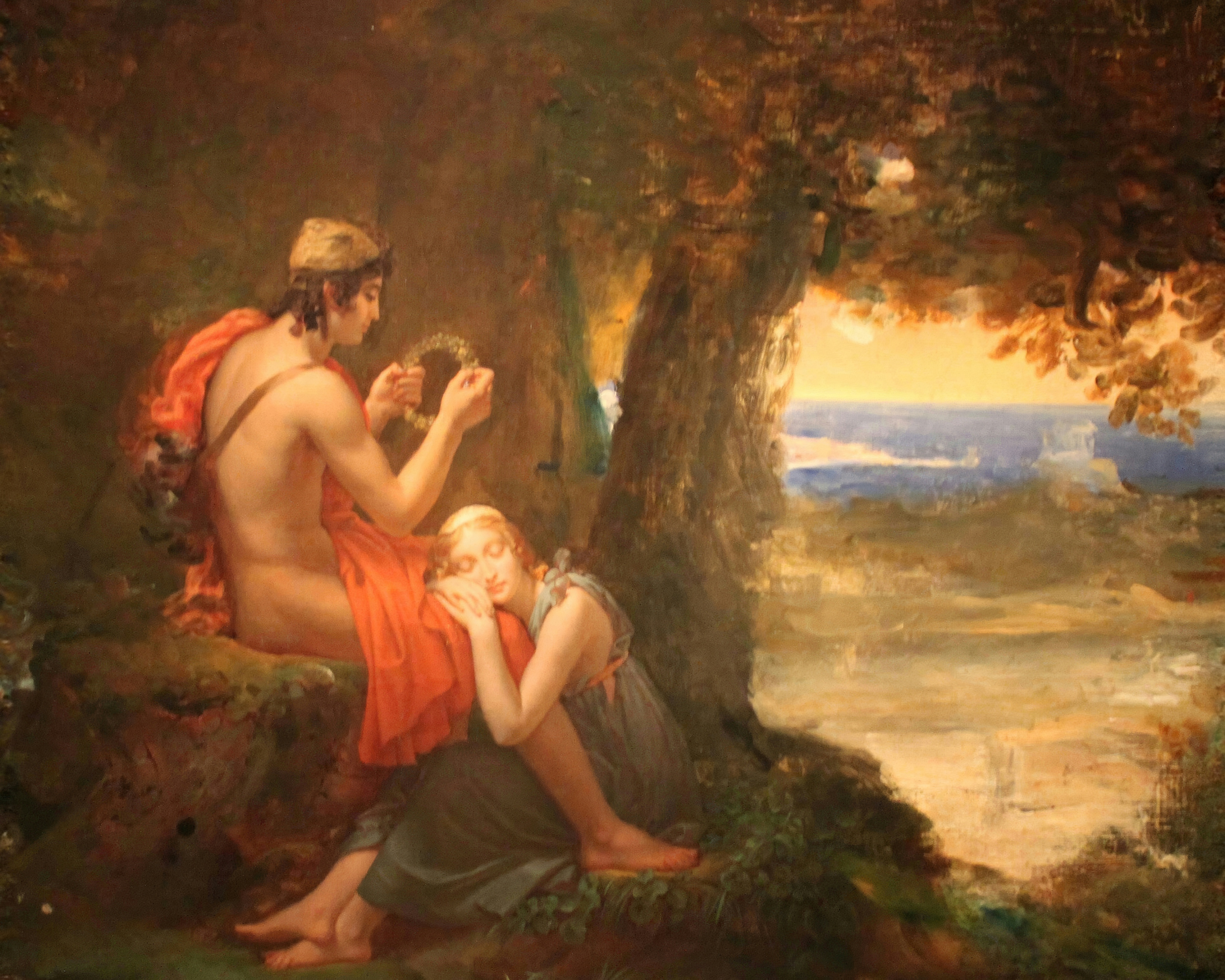 Daphnis, half-draped in a red cloak, seated on a mossy rock holding up a wreath while Chloe sleeps against his knee, under a great tree with a golden sea beyond; painted by François Gérard.