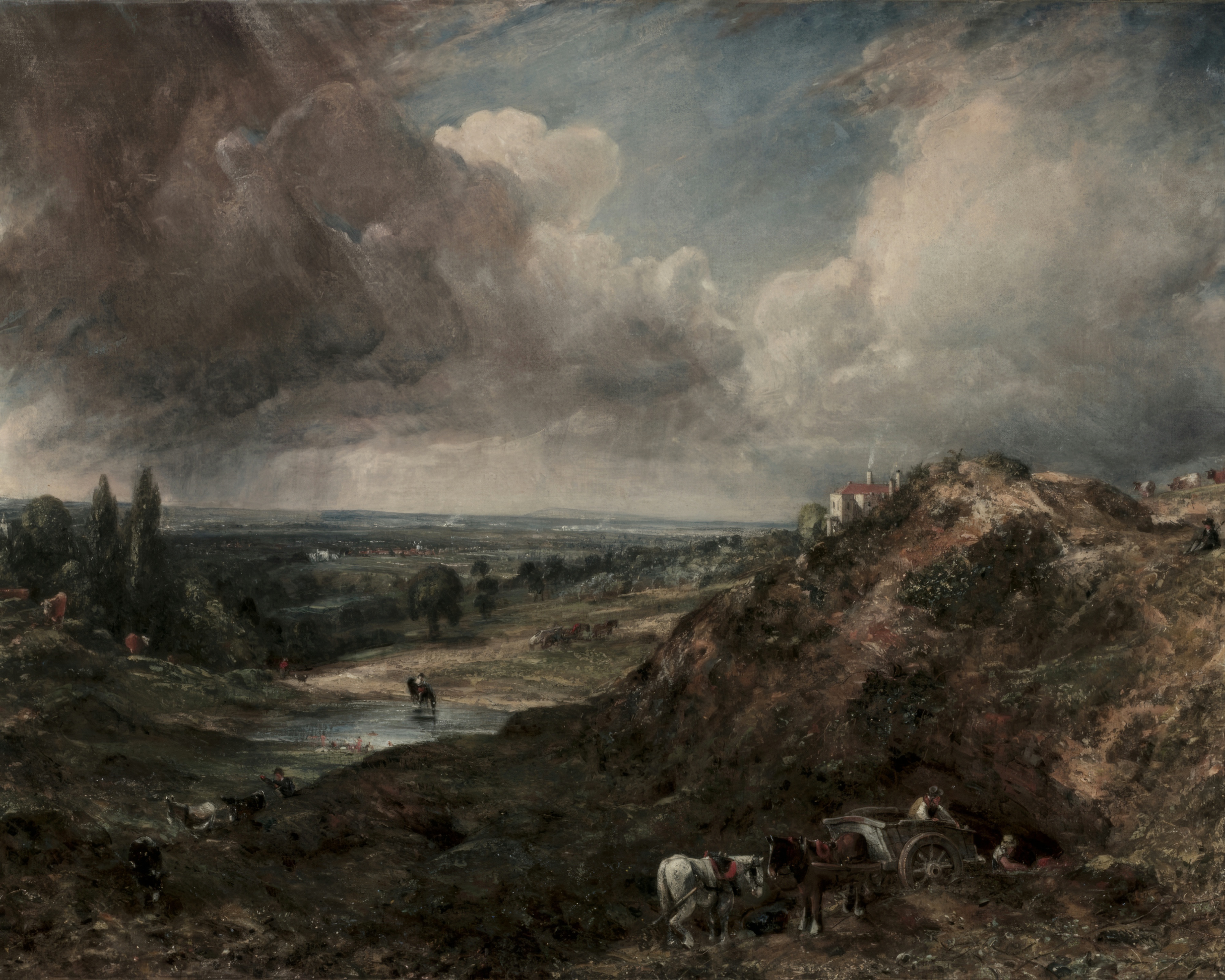 A dramatic cloudy sky rolls over a sandy heath and a small pond at Hampstead.