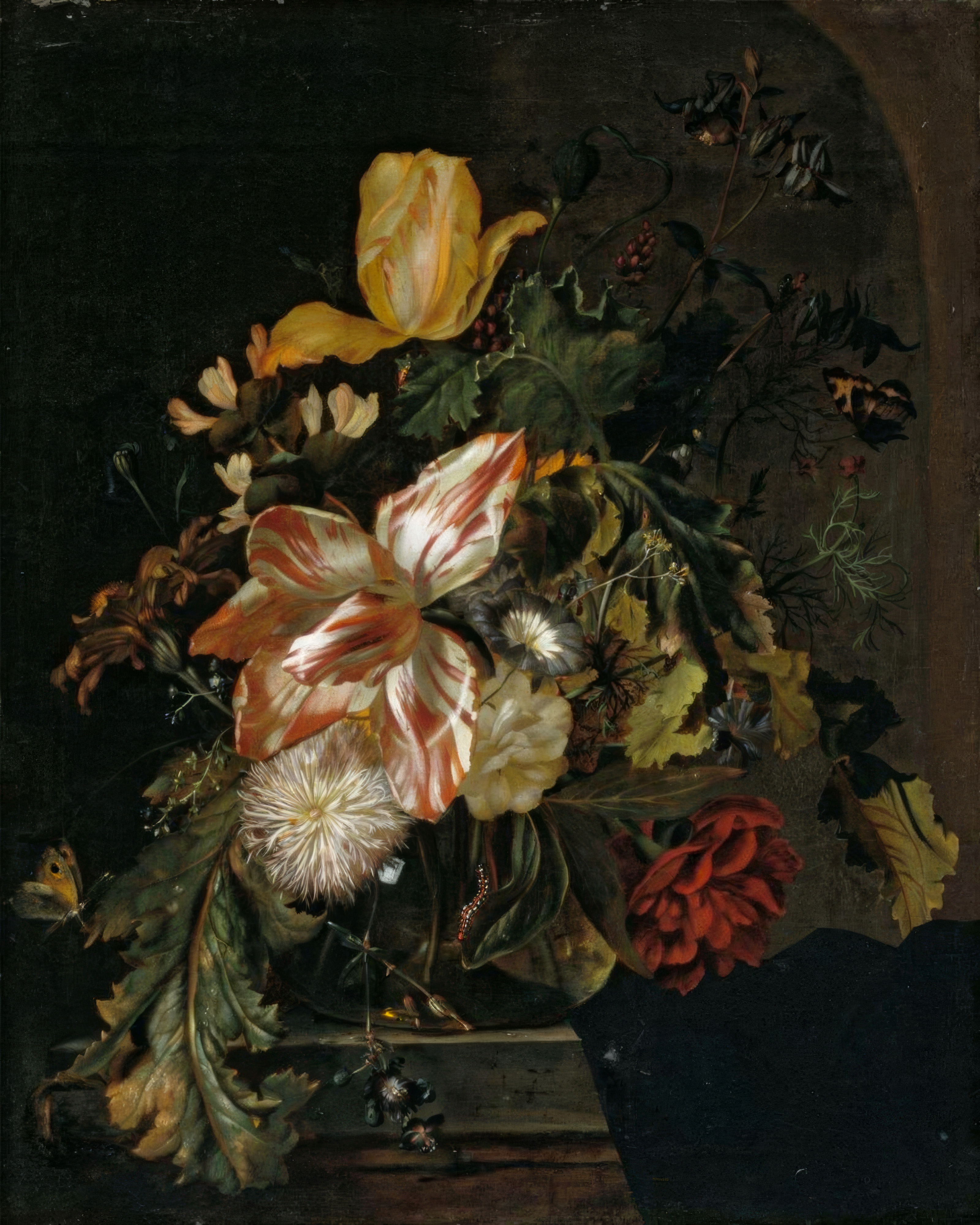 A bouquet of tulips, roses and irises in a plain glass vase against a dark background.