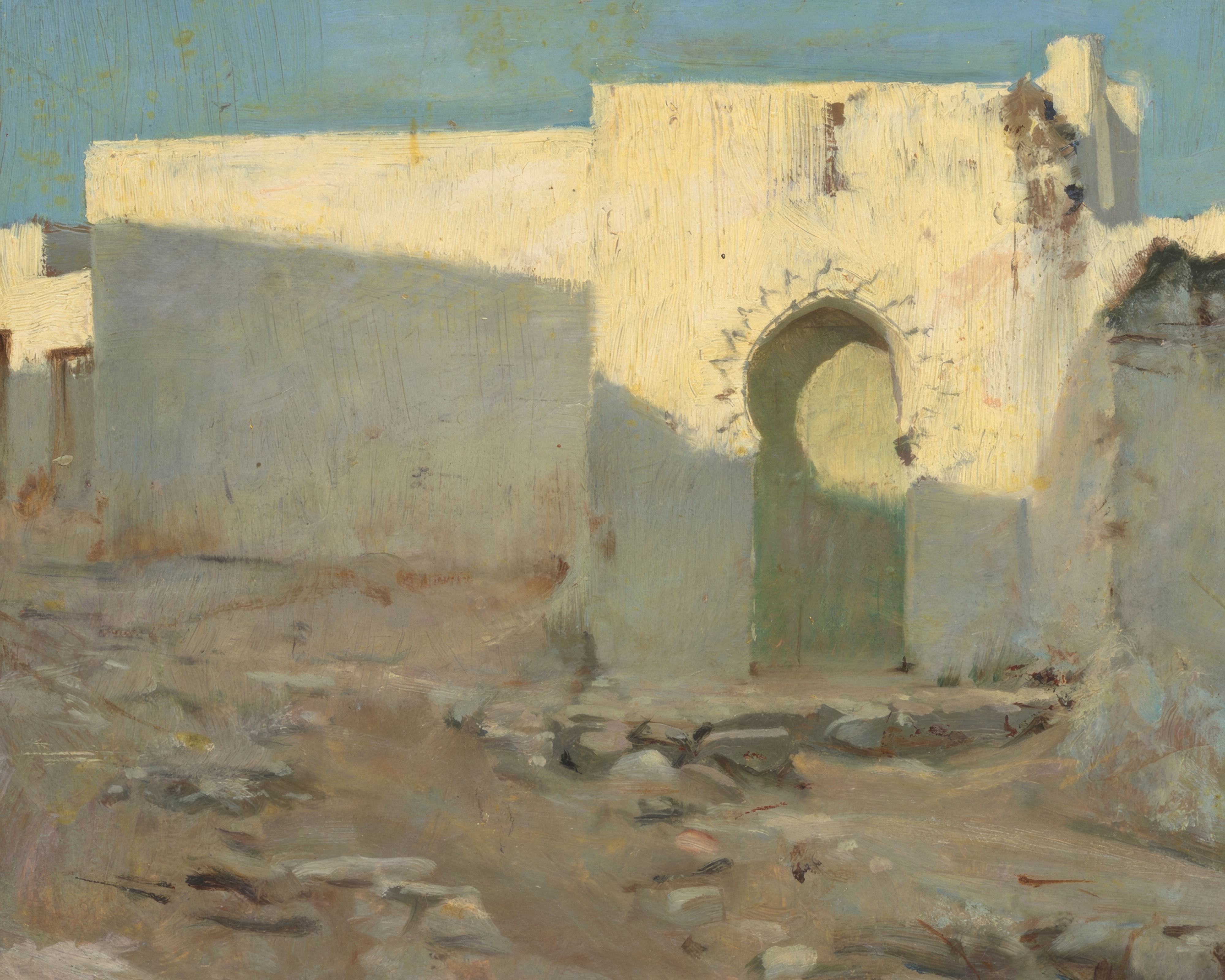 White Moorish walls glow in bright sun under a pale blue sky.