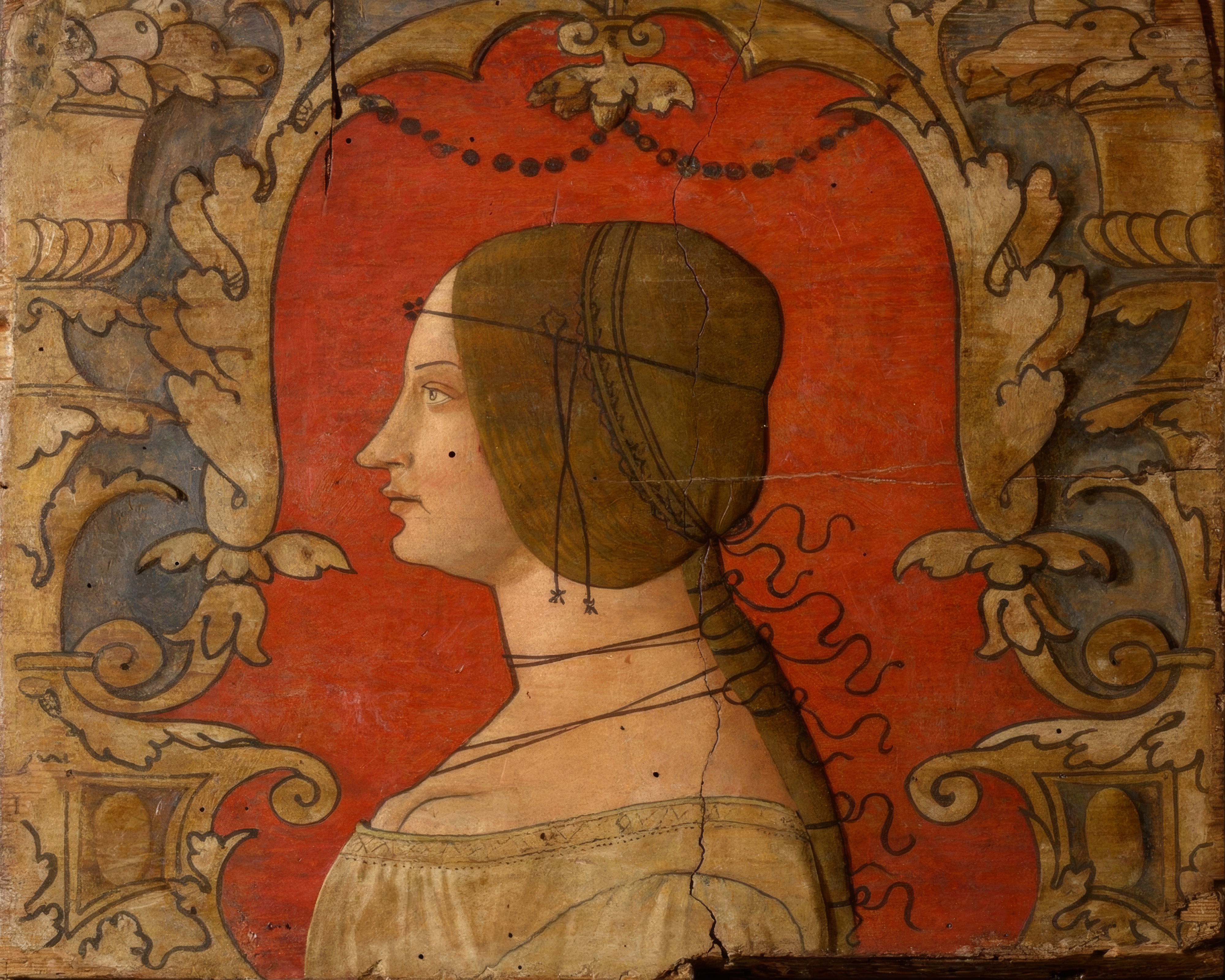 A woman in strict profile facing left, her hair braided and dressed with pearls, in a red gown.