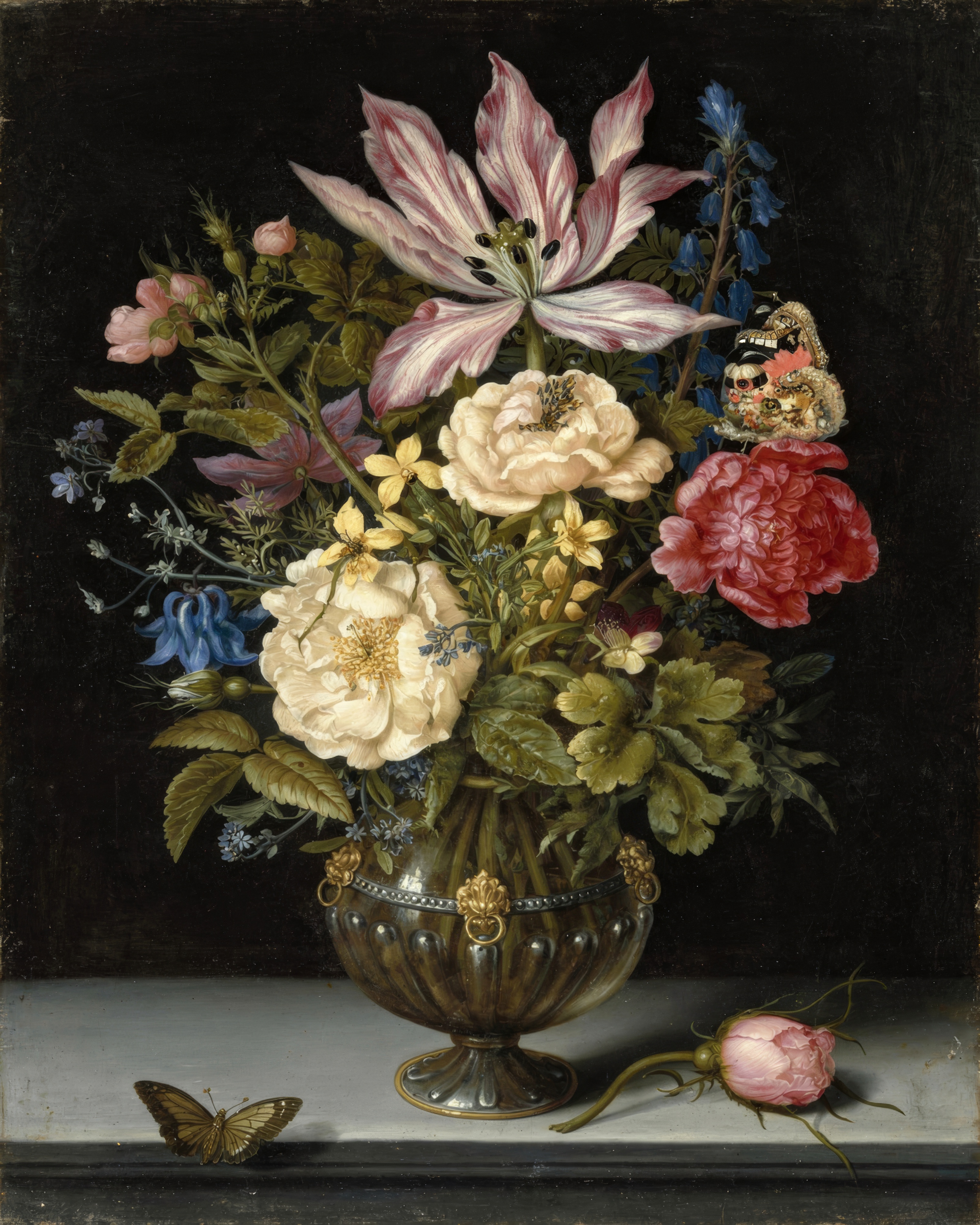 A tall bouquet of tulips, roses, irises and other flowers in a blue and white Chinese vase against a dark background.