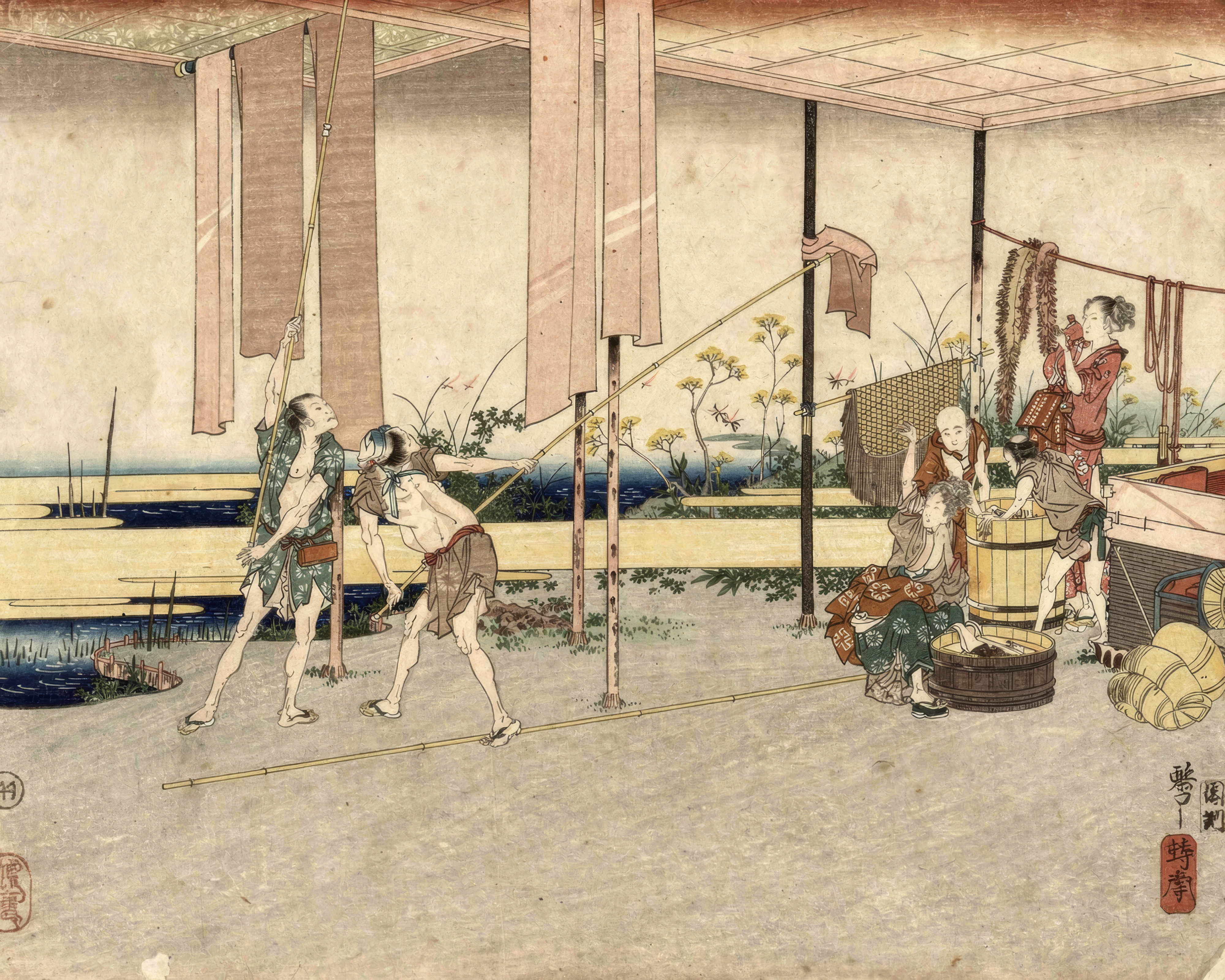 Two dyers pull long bolts of cloth from a vat and lay them out to dry.