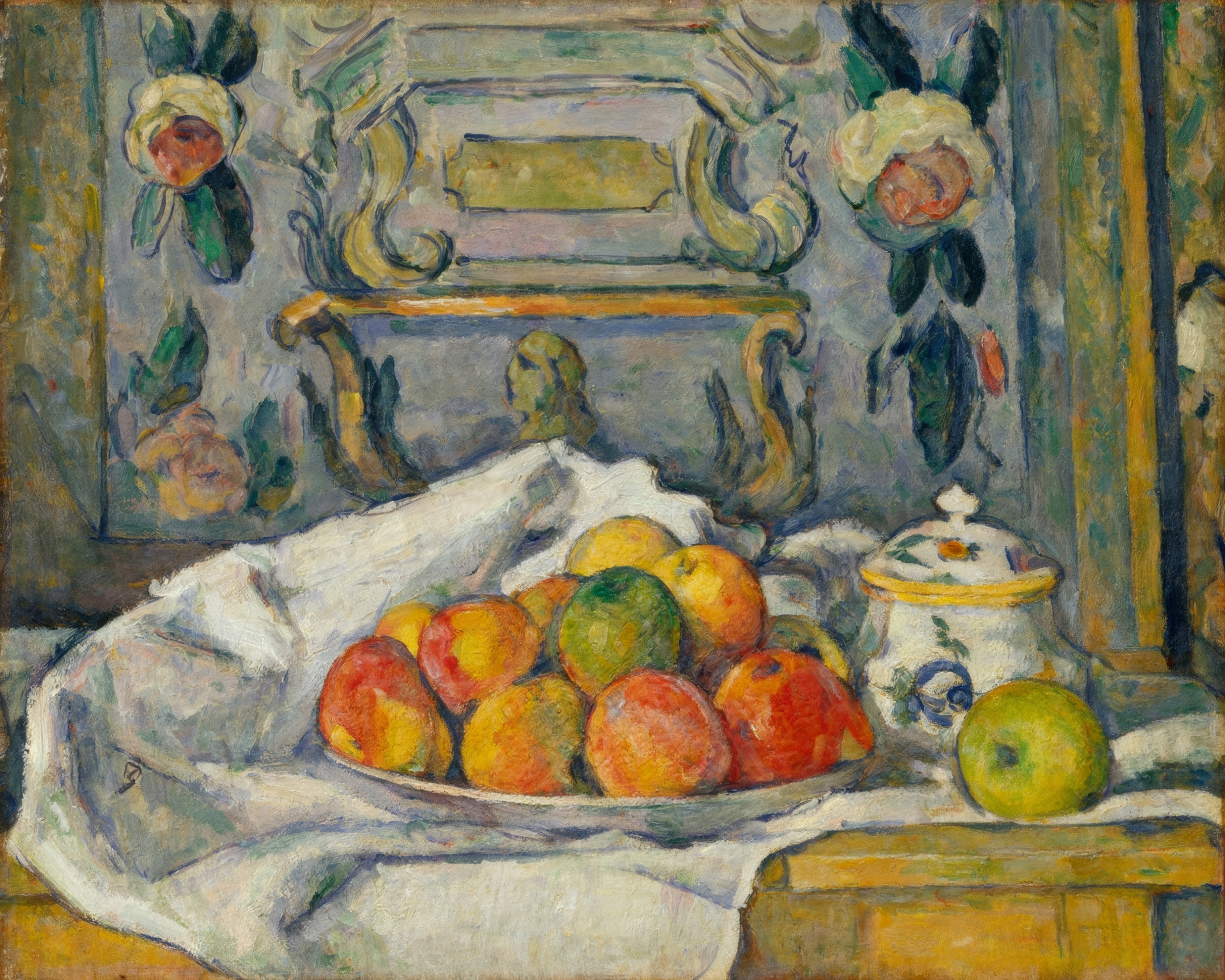 A white dish of red and yellow apples tilted on a rumpled tablecloth.
