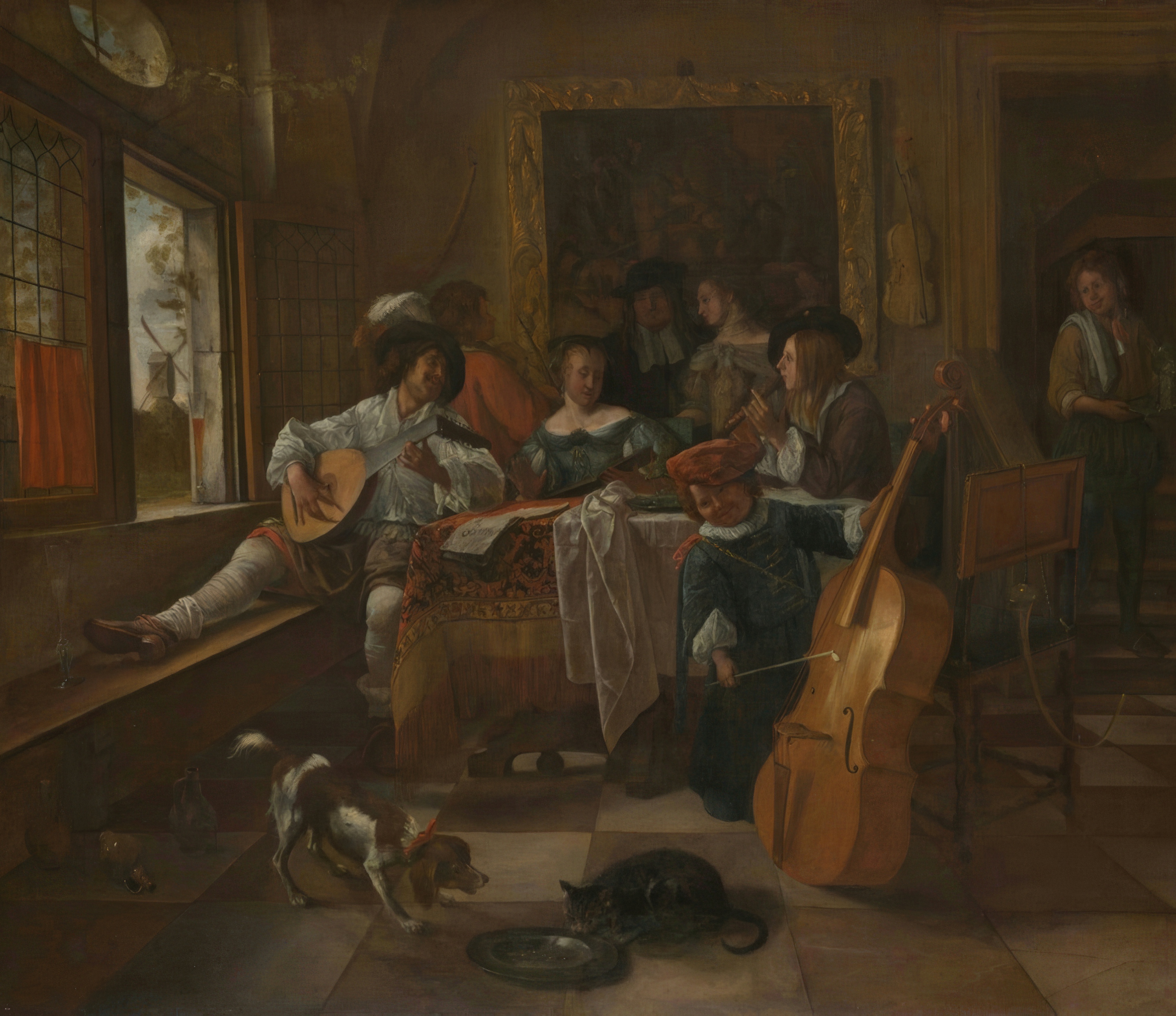 A Dutch family makes music together around a table, a man playing and a boy singing.