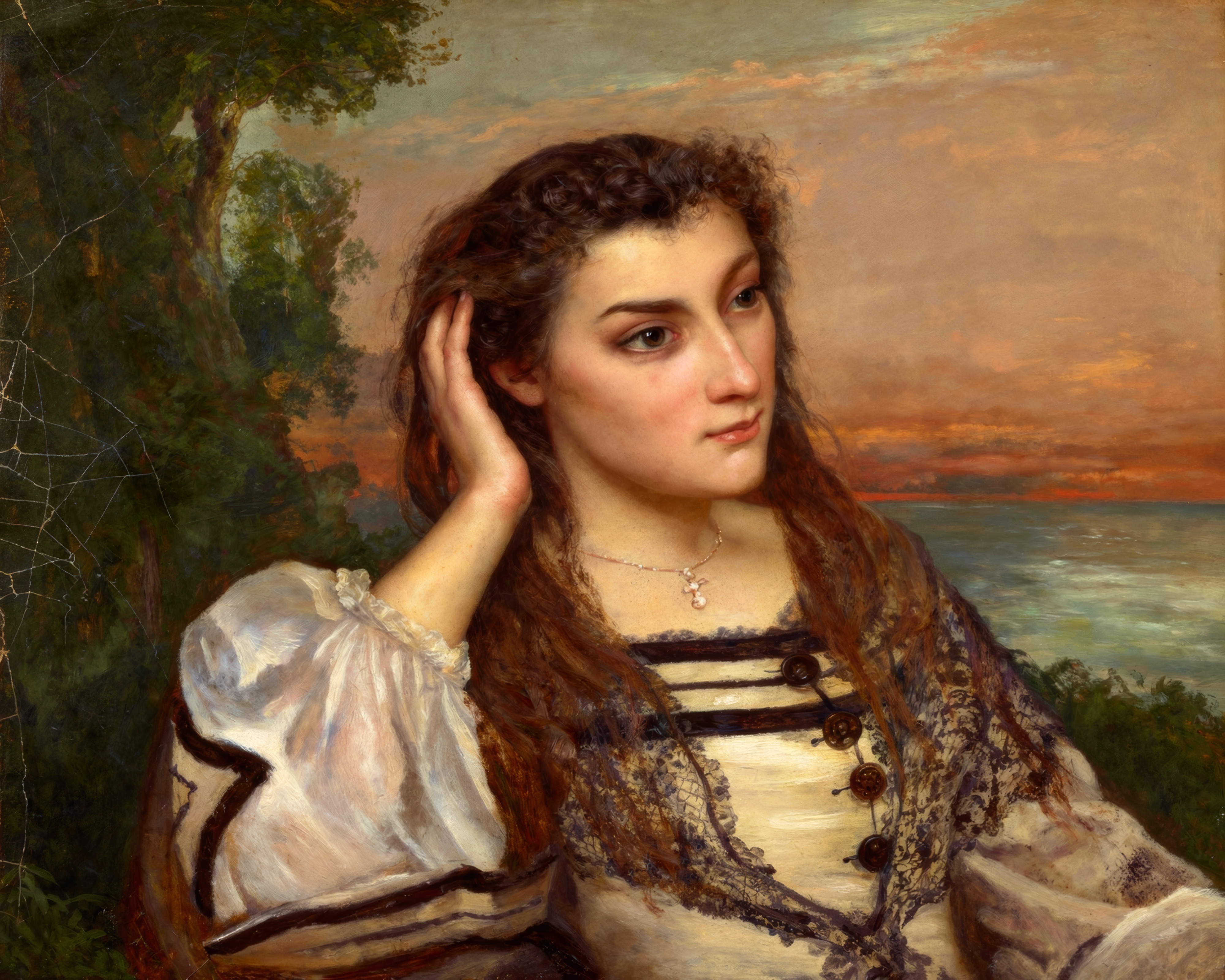 A young woman rests her head on her hand, lost in thought.