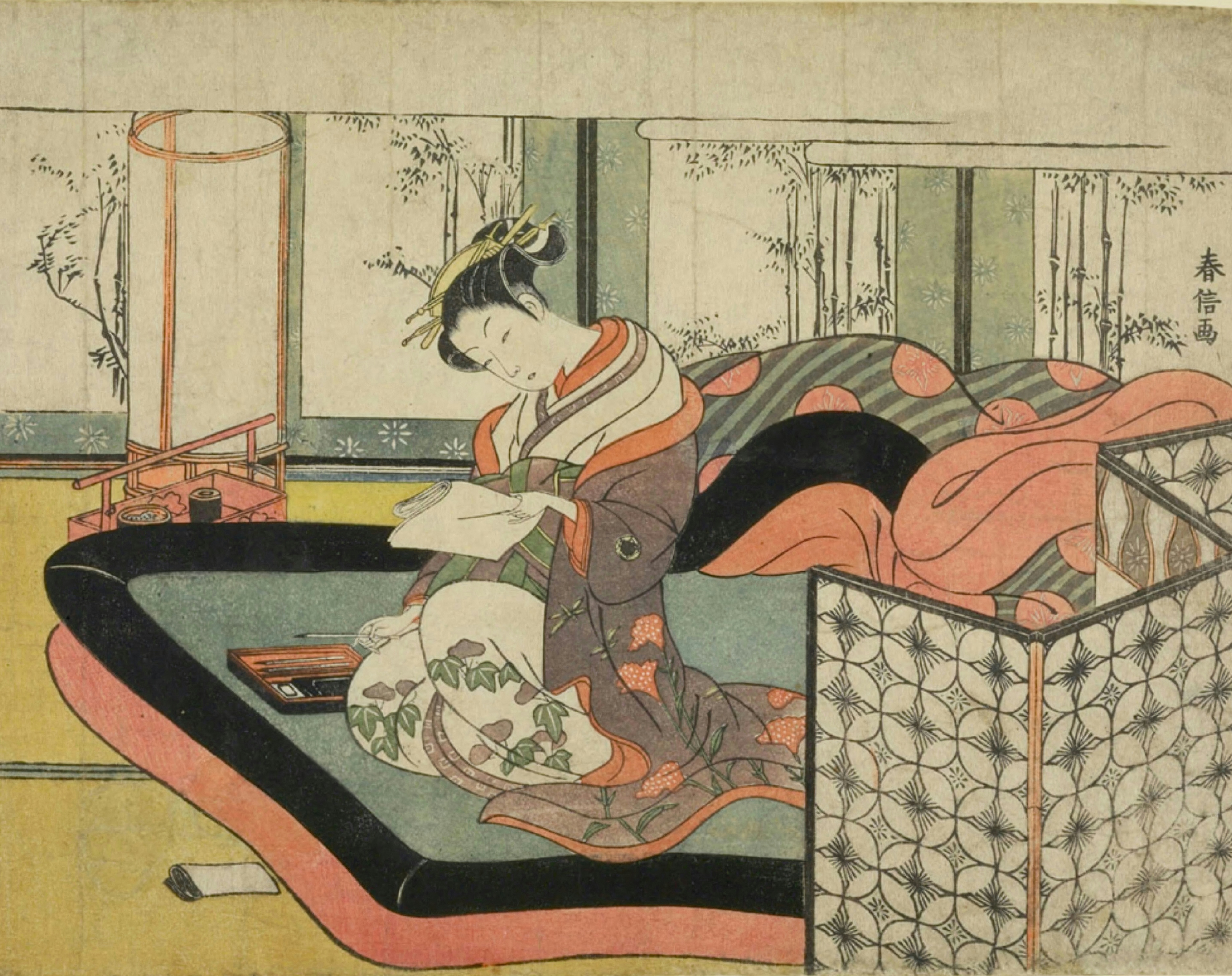 A figure writes a letter, wrapped in patterned bedding.
