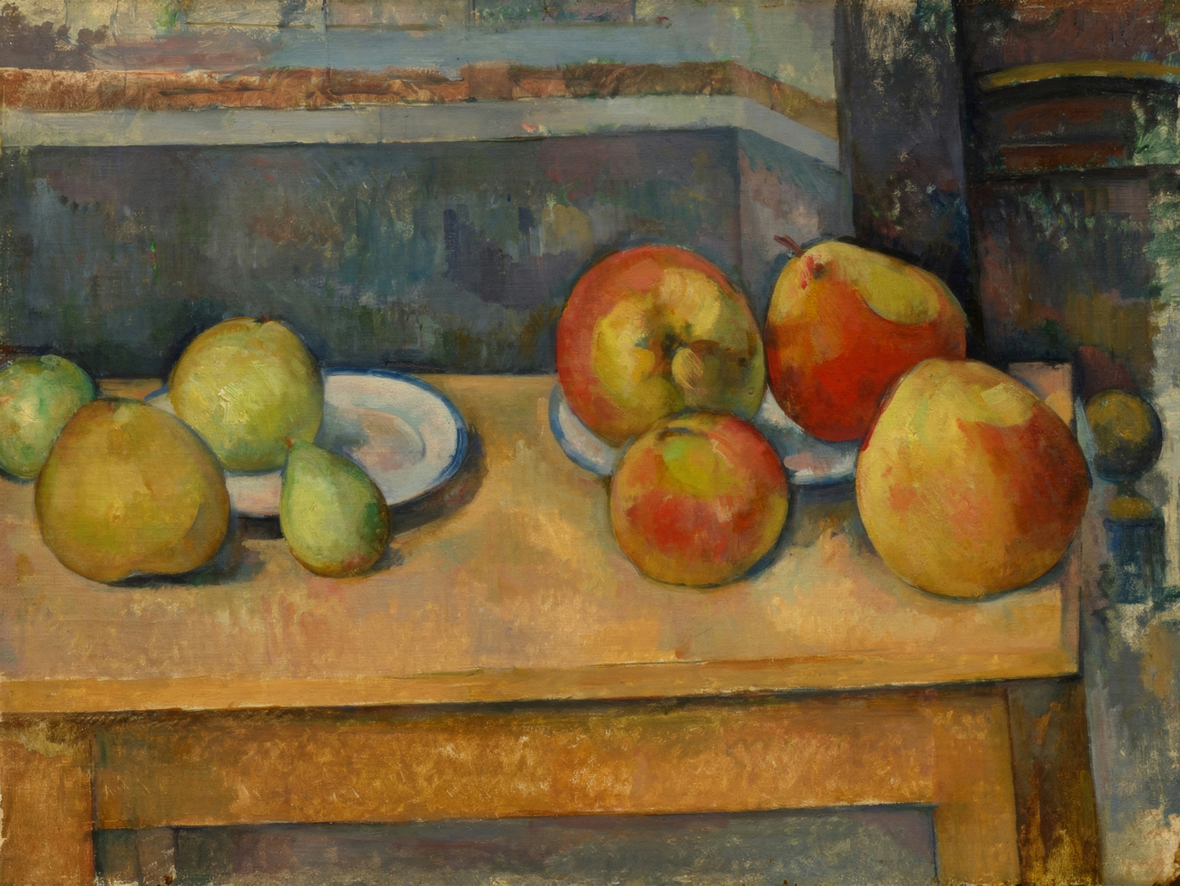 Apples and pears in red, yellow and green on a rumpled white cloth on a table.
