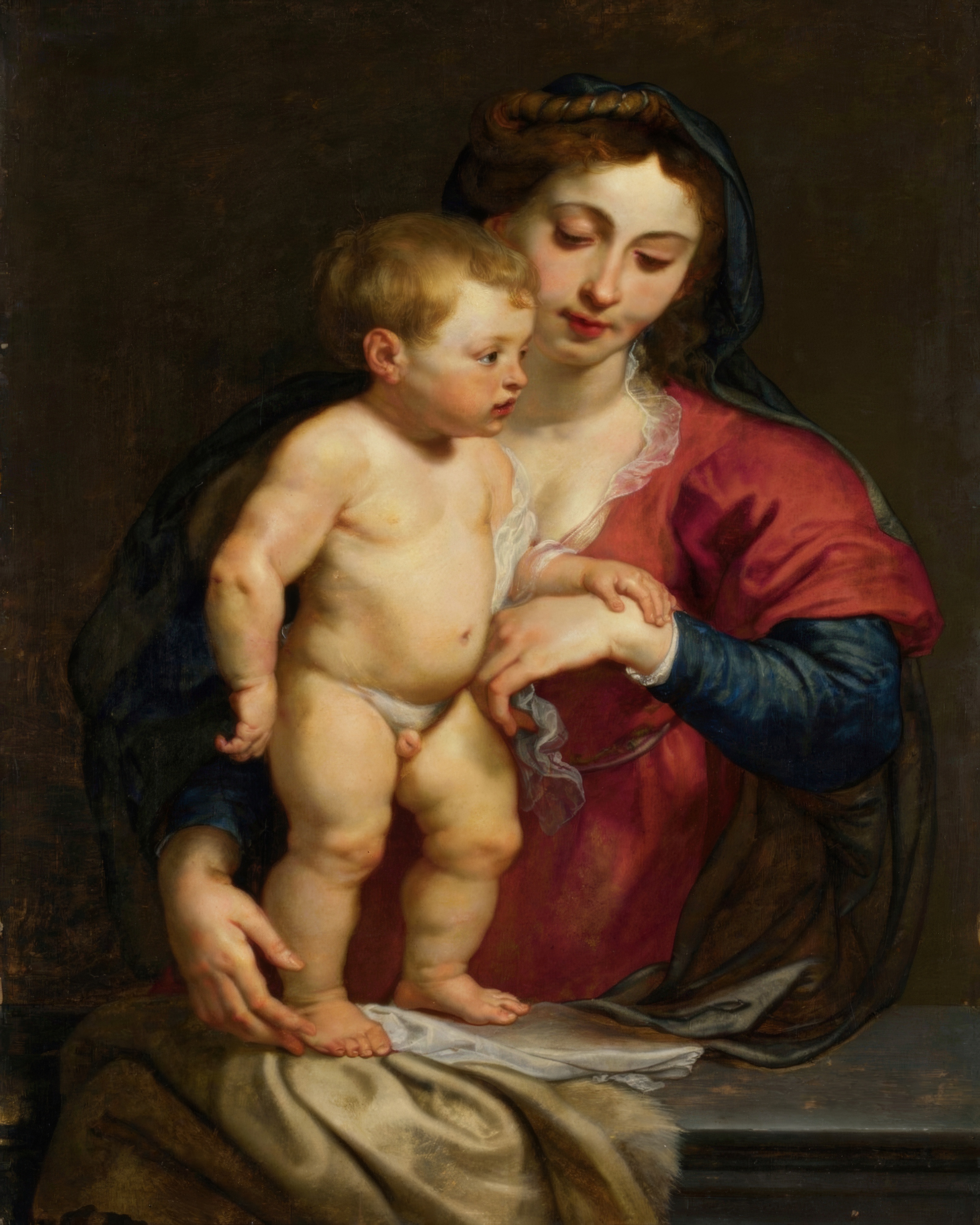 The Virgin holds her child close, their faces lit by warm light.