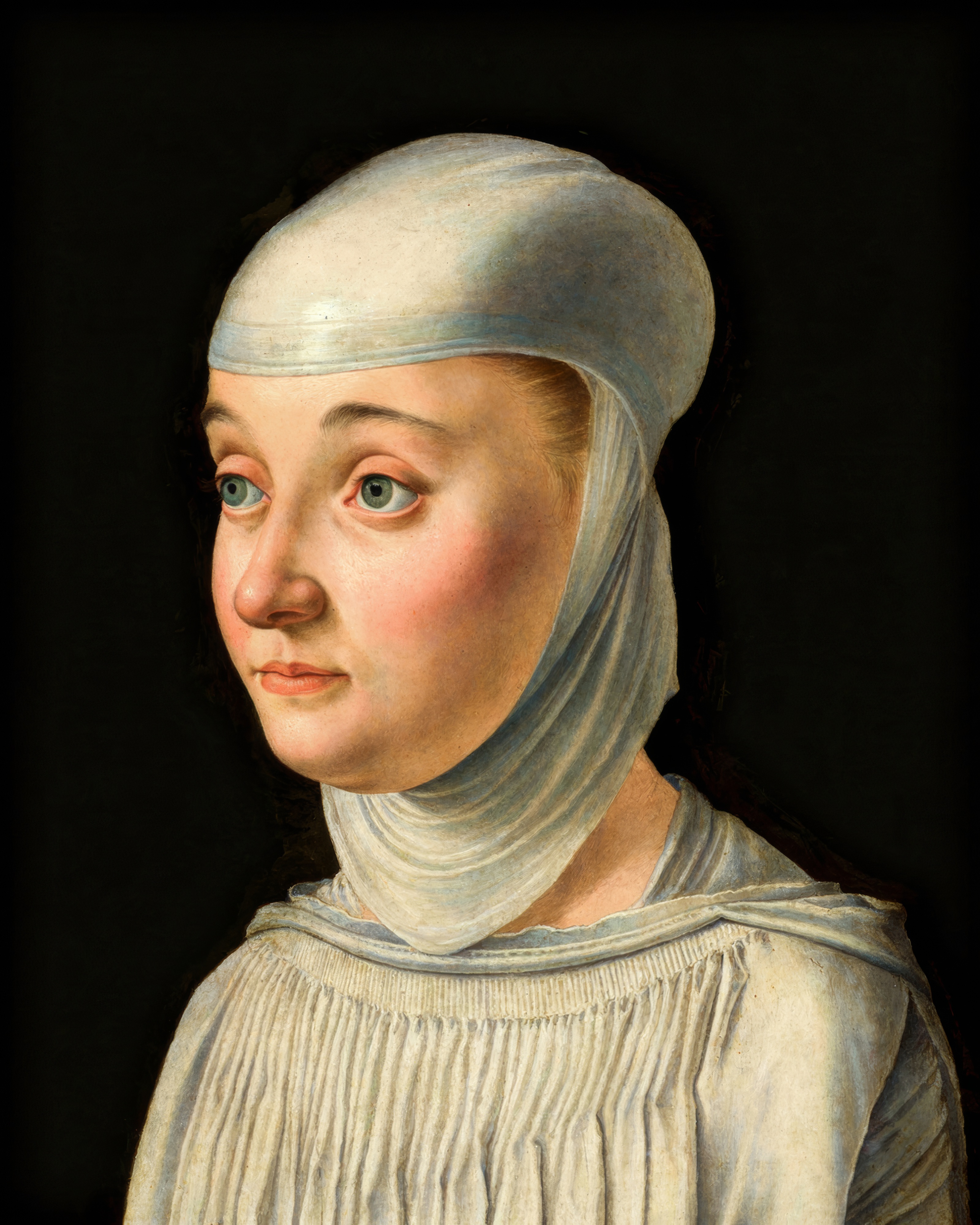 A young woman in a white veil and dark habit, her face calm, set against a black background.
