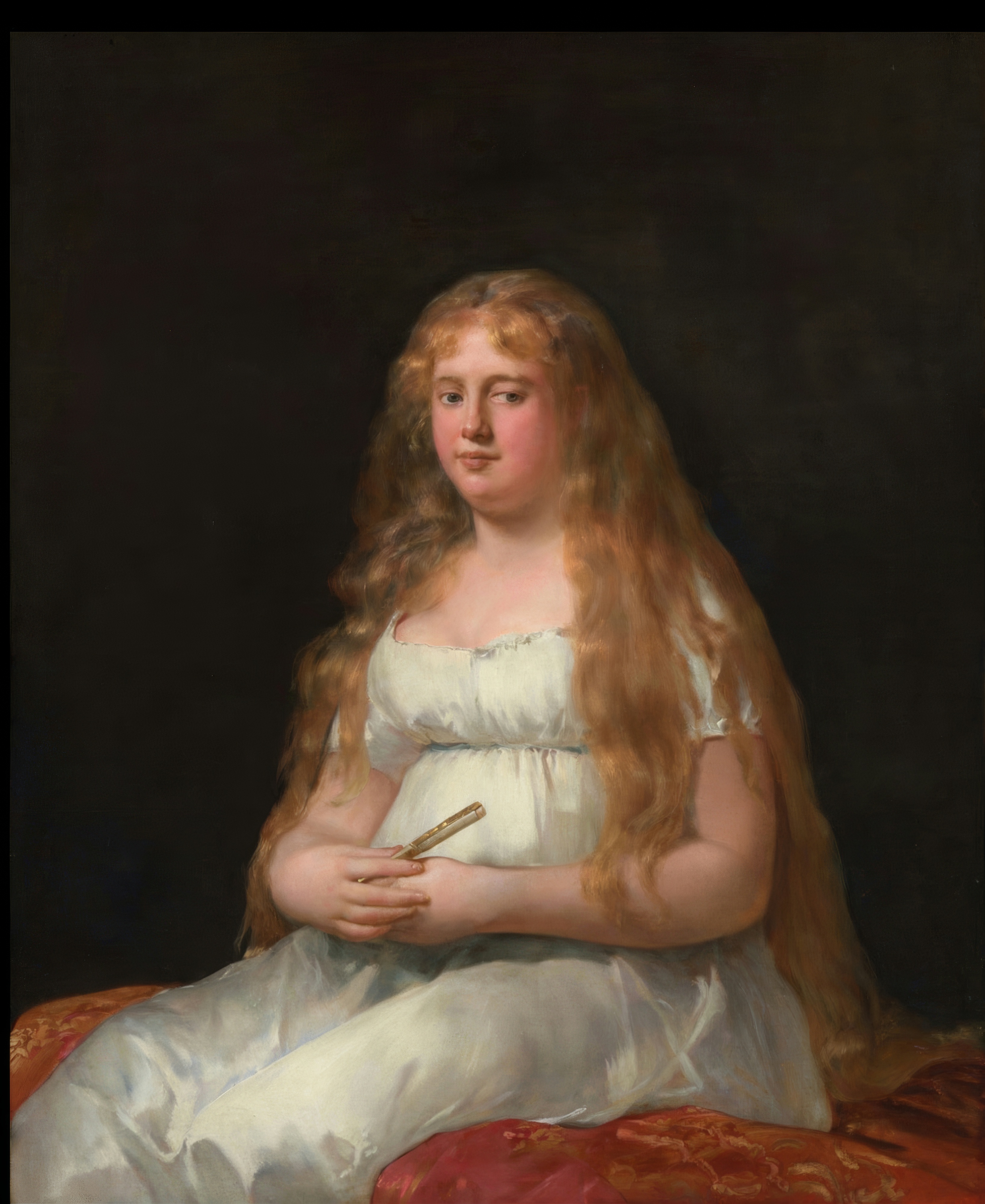 A woman with dark curly hair in a white dress with a gold shawl looks directly at the viewer.