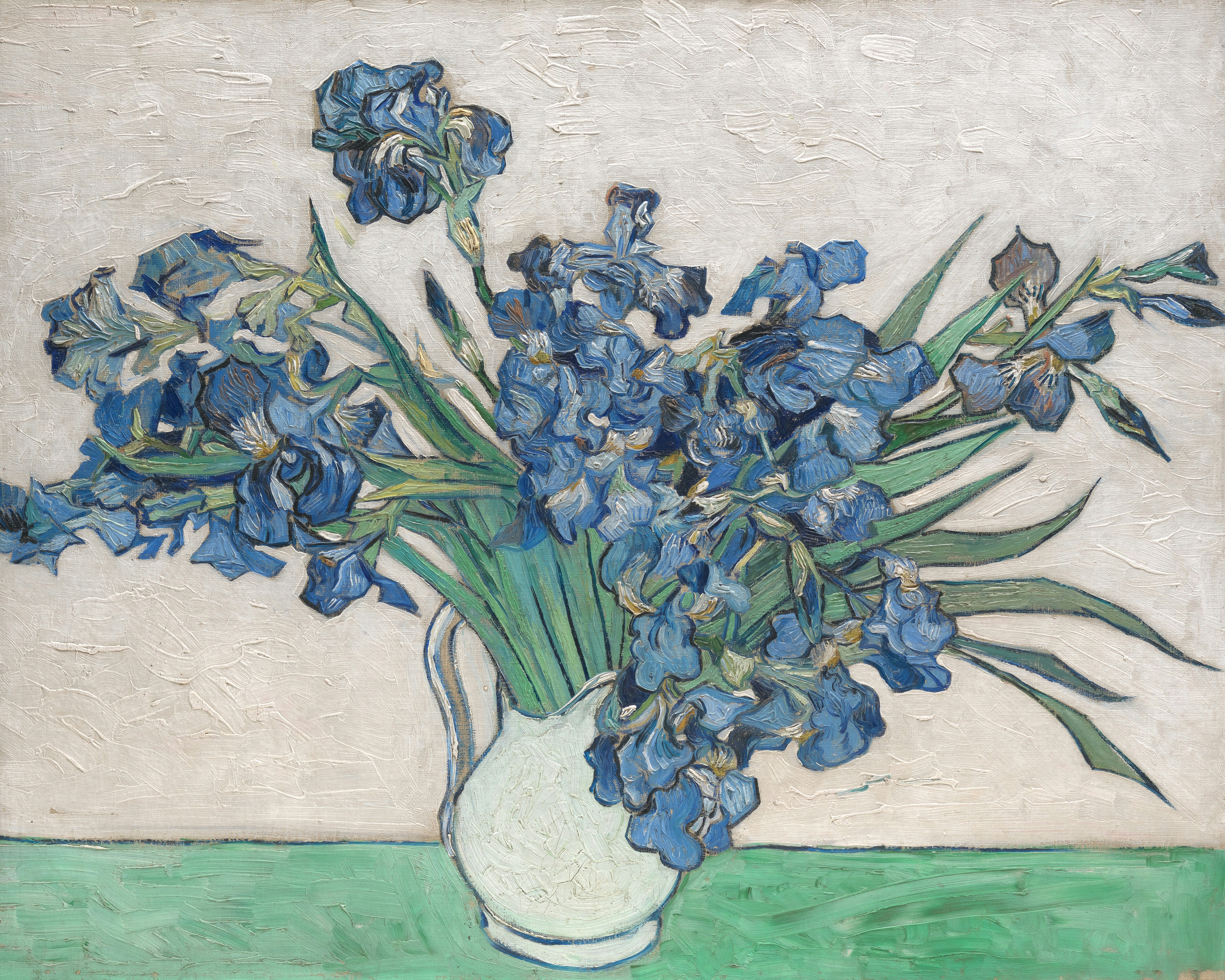 A bouquet of purple-blue irises in a vase against a pale yellow-white background.