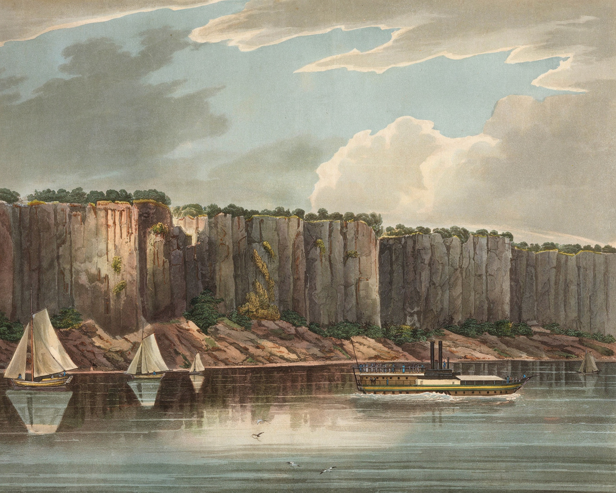 The sheer cliffs of the Palisades rise above the Hudson with small sailboats below.